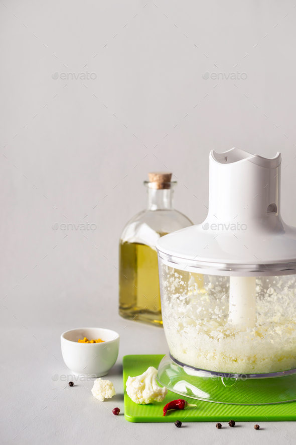 Blender bowl with freshly prepared cauliflower rice and spices